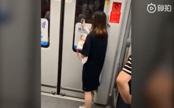 上海女子用手机砸地铁门还欲拉紧急制动 