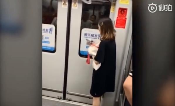 上海女子用手机砸地铁门还欲拉紧急制动 