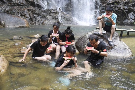 湖南九龙江游人溯溪吃西瓜避暑_溪水