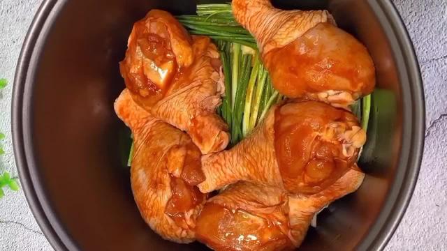 鸡腿摆入电饭煲中,码放整齐后,再加入1勺清水,它可以起到防止粘锅的