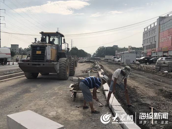 光明路与淮河路路口工人正在铺设路沿石