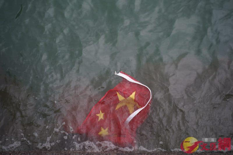 并扔入海中,期间发出嬉笑声,国旗不久后被海水卷走消失