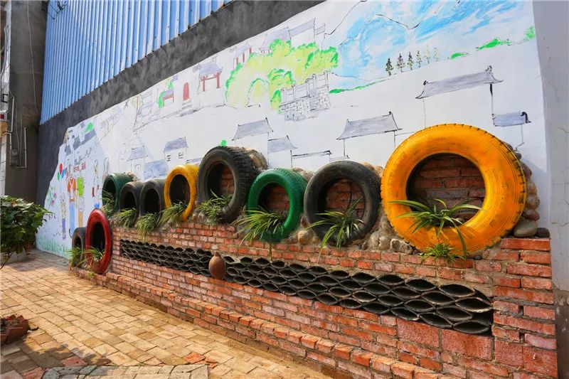 马家店街道江口社区利用旧墙,轮胎打造的文化微景观.刘斐 摄