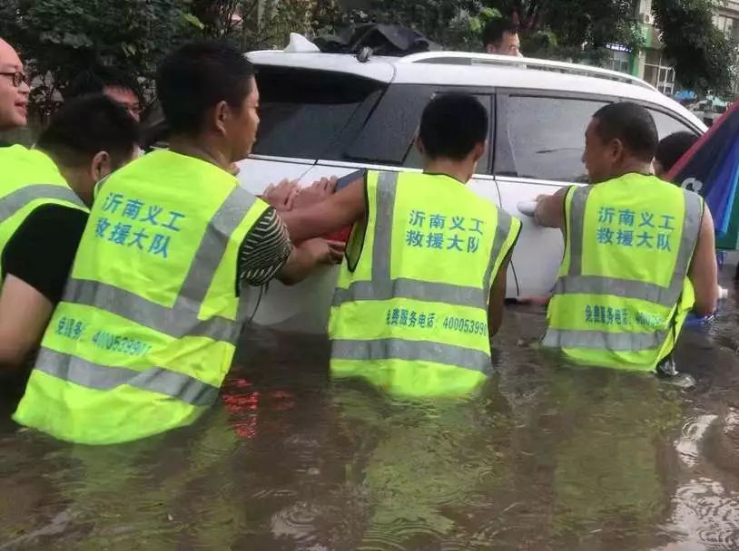 70多位"雨衣"志愿者在水位超标的危险路段负责排水工作他们站在排水口