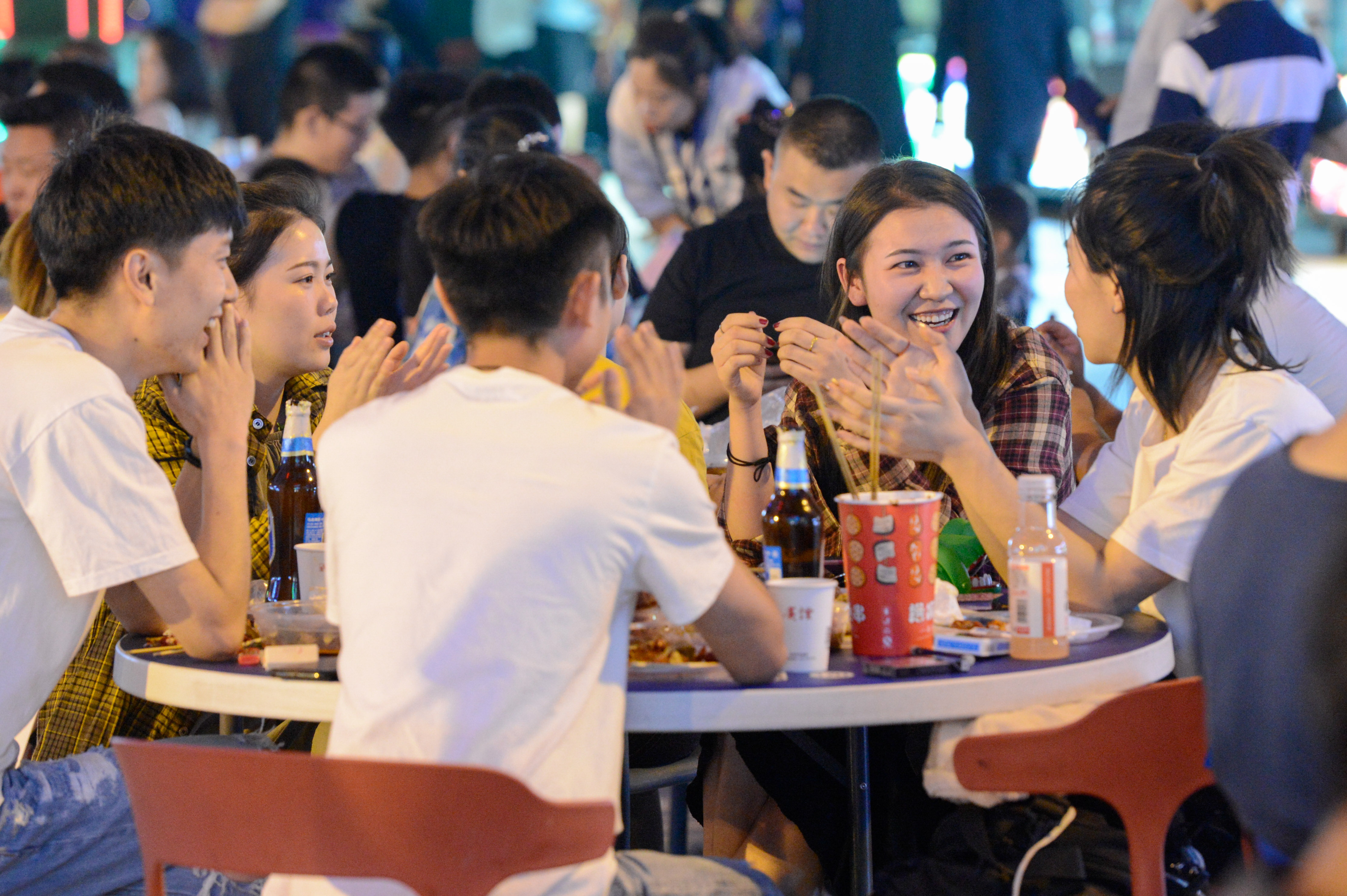 人们在乌鲁木齐五一星光夜市上品尝美食(7月5日摄 新华社记者丁磊摄