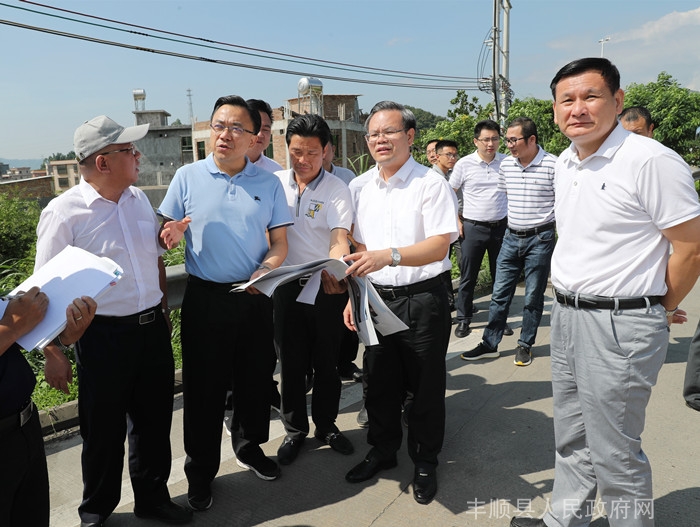 在县委书记曾永祥的陪同下到丰良镇韩山景区国道入口处调研(胡金辉摄)