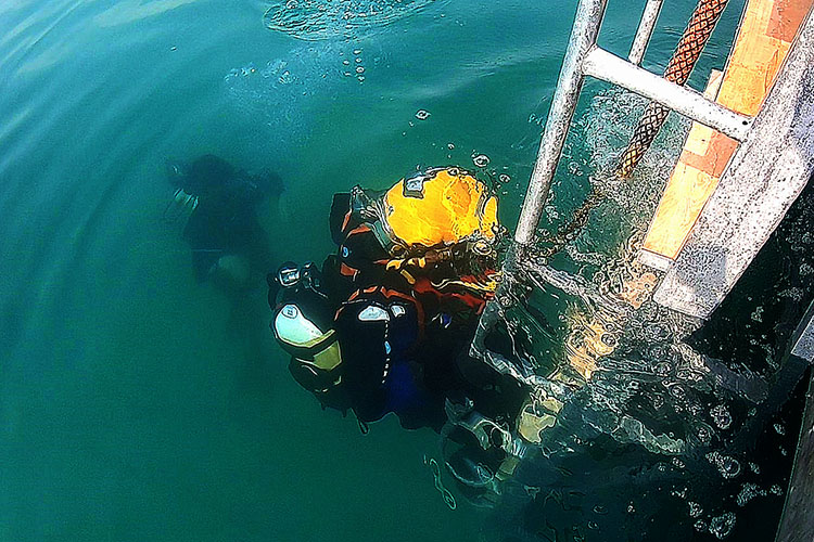 潜水员完成任务出水.水中救援.潜水员携带食物桶下潜.
