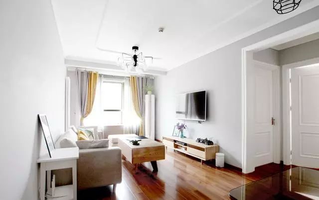 这是客厅,墙面通刷了浅灰色乳胶漆,木色家具简约质朴,双色窗帘给这个