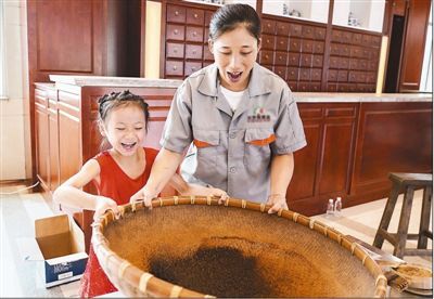 8月13日,小学生在药工的带领下体验手工制作中药技艺.