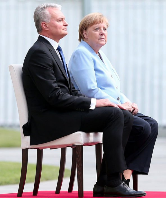 默克尔连续3次颤抖后，坐着和外宾听国歌