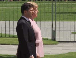 默克尔连续3次颤抖后，坐着和外宾听国歌