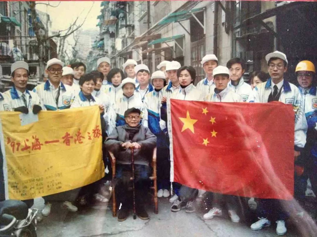 国旗设计者曾联松在国旗上写下“庆香港回归”，这一珍贵的国旗从上海一路骑行到香港……