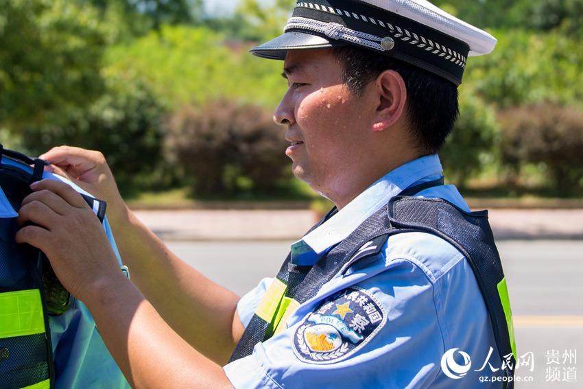 一名交警在帮同事整理肩章.田东 摄