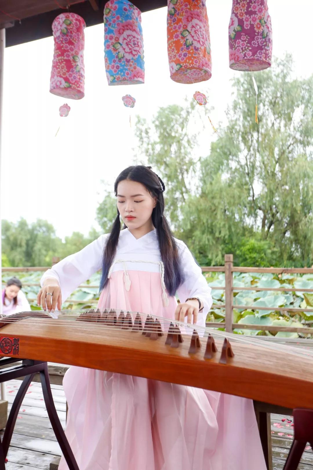 一袭汉服,一台古筝,临水而坐,轻抚琴弦,画面和谐优雅,举手投足之间