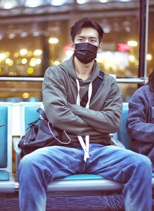 李现穿着非常普通的一个连帽卫衣搭配牛仔裤,还戴着一个黑色的口罩略