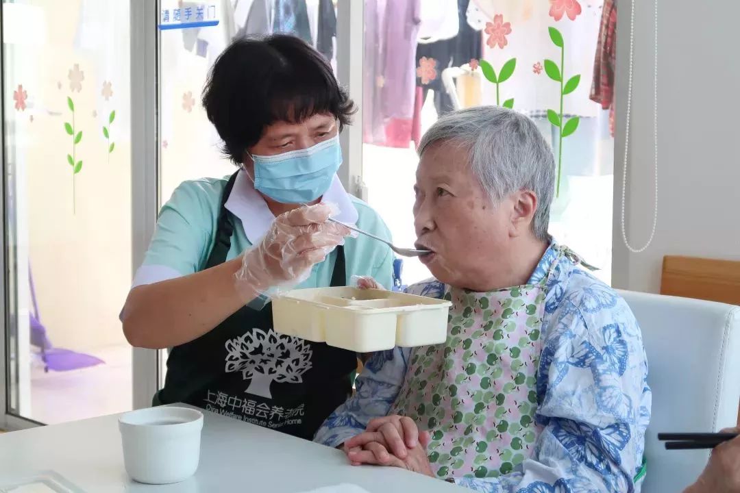 护理员正在喂老人进食