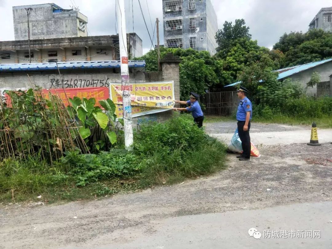 防城区珠河街道办工作人员在整治山海大道卫生死角和清理杂草.