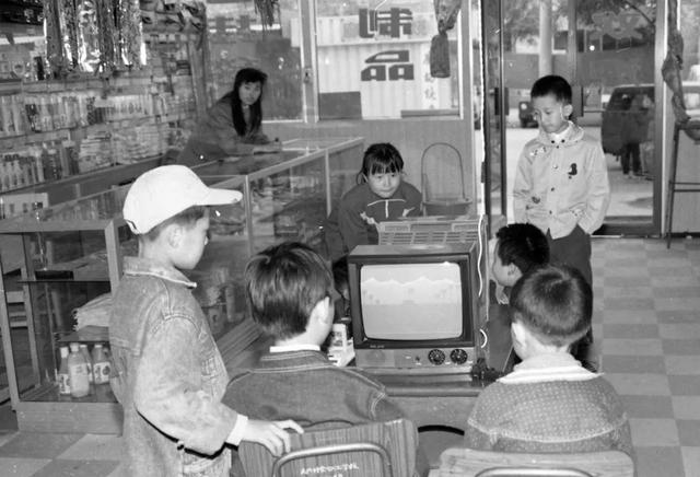 上世纪90年代,北京,孩子们在商店内的电子游戏机前玩游戏.