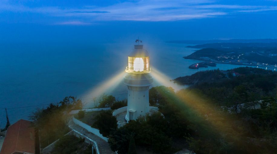 入夜,两道旋转的光束从老铁山灯塔射出,照亮黄渤海的夜空.