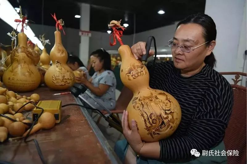 韩玉梅在亚腰葫芦上作画.图片来源:阜阳文明网