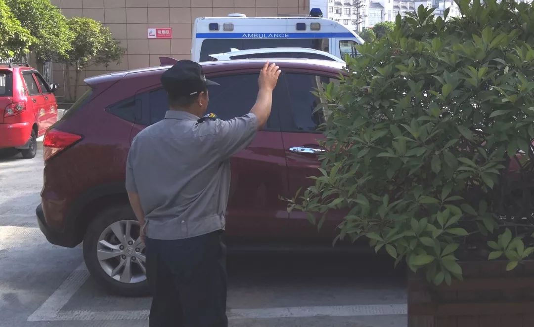 图为保安师傅指挥倒车入位