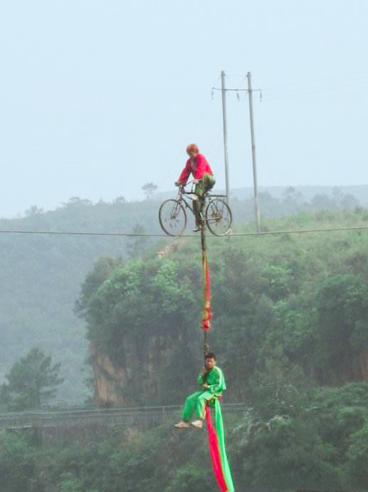 1400米的山体之间的高空钢丝上进行,由6位特技艺人骑行自行车,独轮车