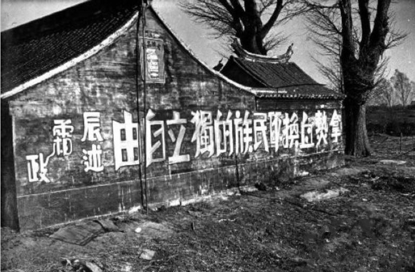 时期标语:1940年,一位代人写信的老先生自发在身后墙上书写抗日标语