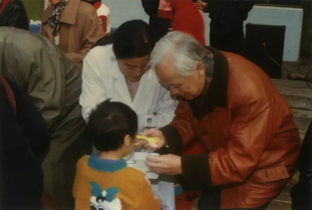 1993年,顾方舟在河南基层参加儿童小儿麻痹糖丸免疫播种,给孩子喂食