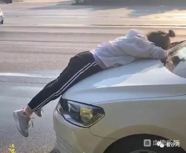 清华园附近一女子与人发生冲突,趴在车前被拖行一段距离.