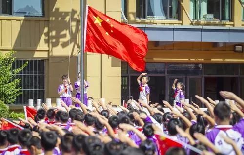 新一年级学生们个个手里挥舞着小红旗,头戴和平鸽造型头饰,朝气蓬勃.