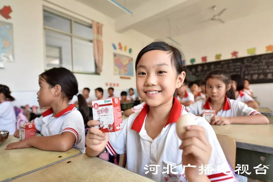 小学生们品味着开学"礼物,脸上露出幸福快乐的笑容.