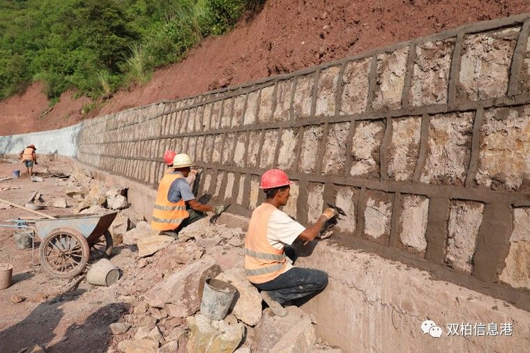 马龙河沿河公路上正在挡墙勾缝的工人