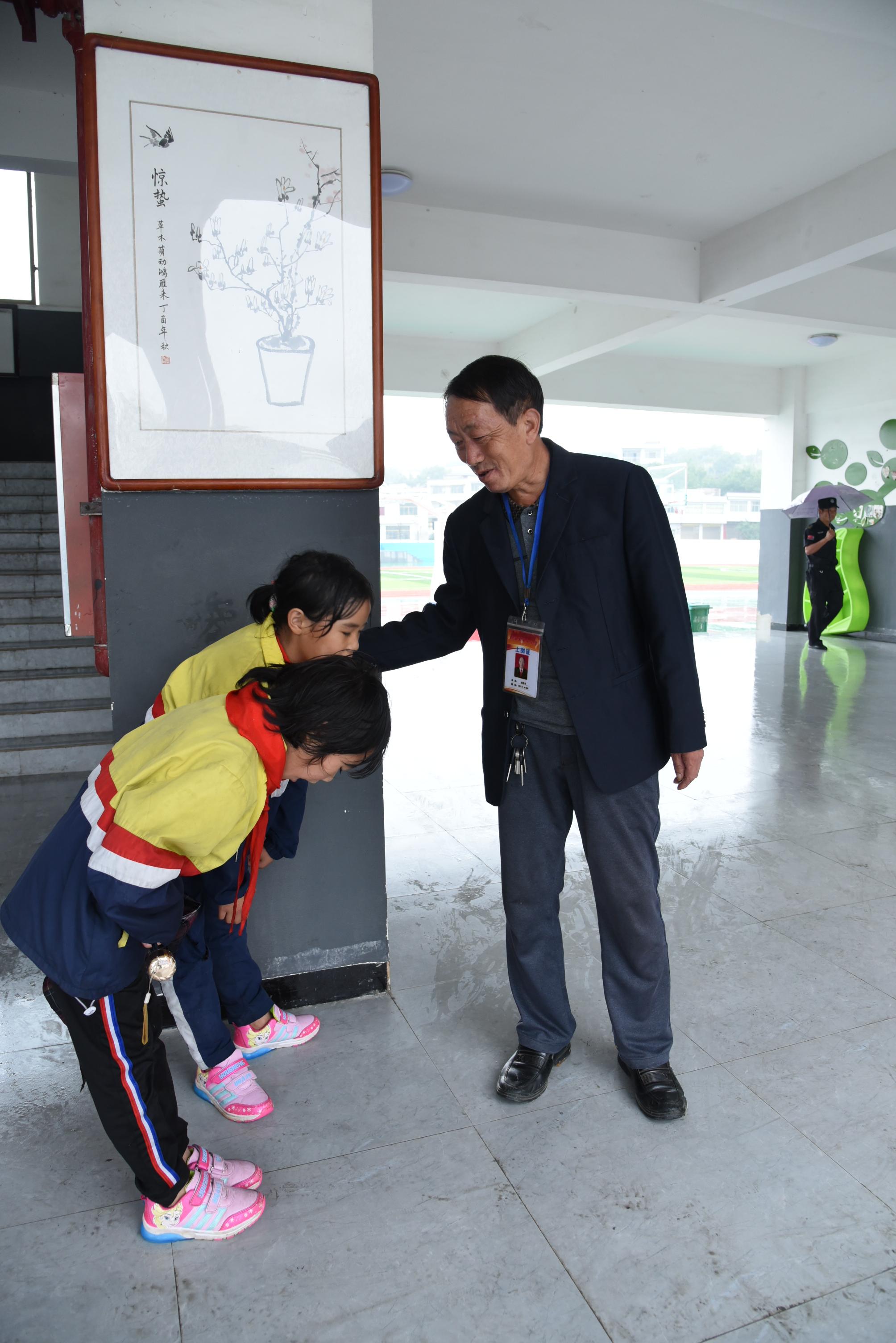 在贵州省黔西县第十小学,小学生向杨绍书问好(9月2日摄.