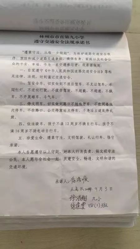 教师、学生、家长一起携手，郑重在《遵守交通法规安全承诺书》签下名字