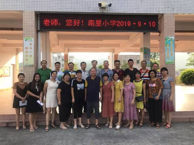 龙颈镇南星小学全体教师为教师节照相留念,学校集中学生在升旗台前,并