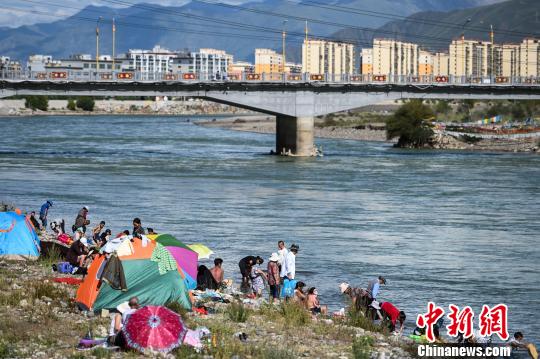 何蓬磊 摄图为藏族民众在拉萨河沐浴.