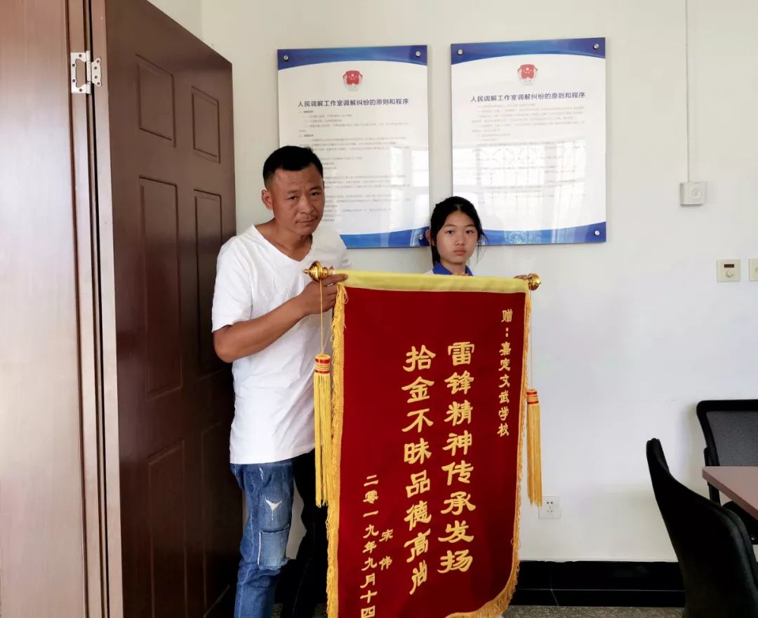 派出所里，宋先生握着七年级学生薛佳欣的手连声感谢，并送上了锦旗。▼