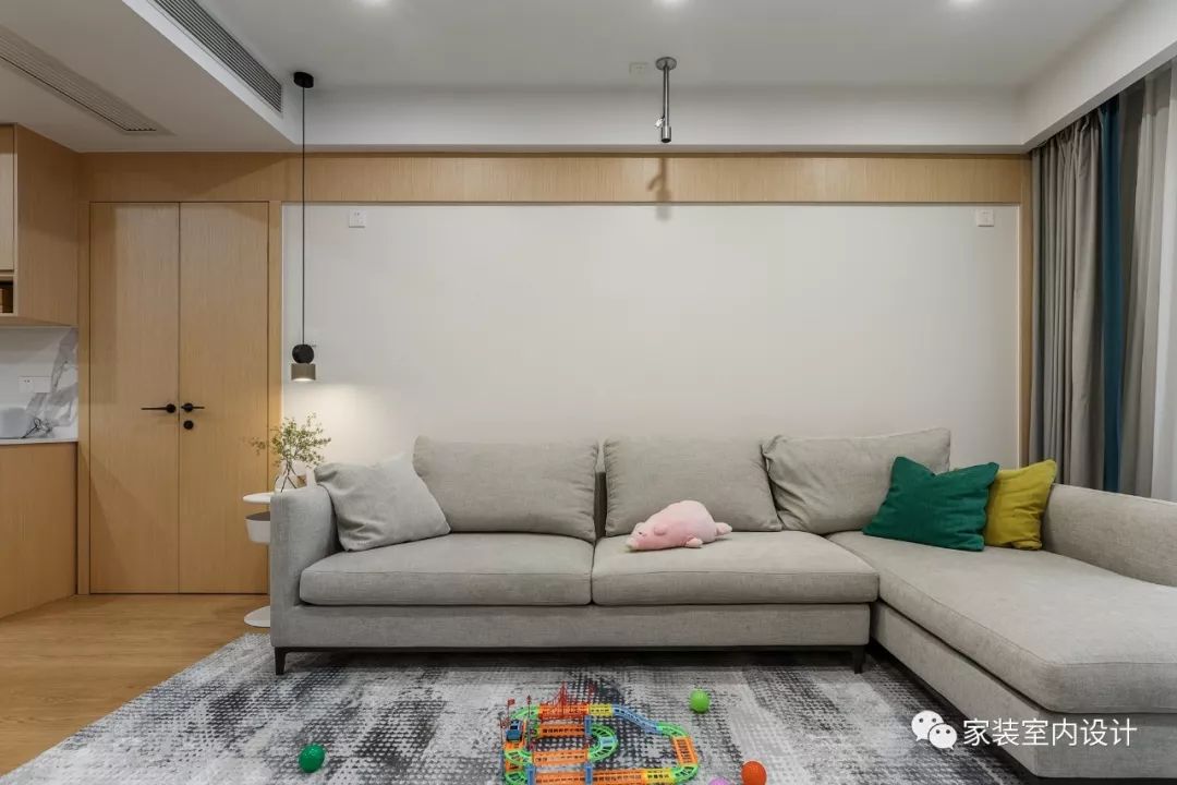 利用隐形门和护墙板造型的延伸,将沙发墙做成一整面完整的背景,也完美