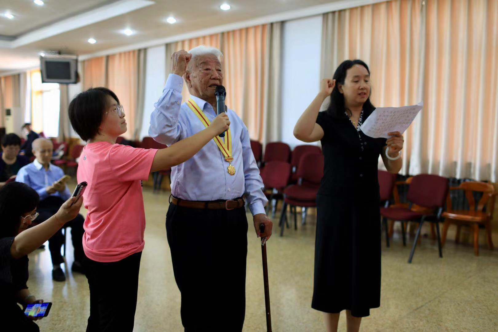 "学院路街道党工委副书记孙渤握着老人的双手,高兴地说.