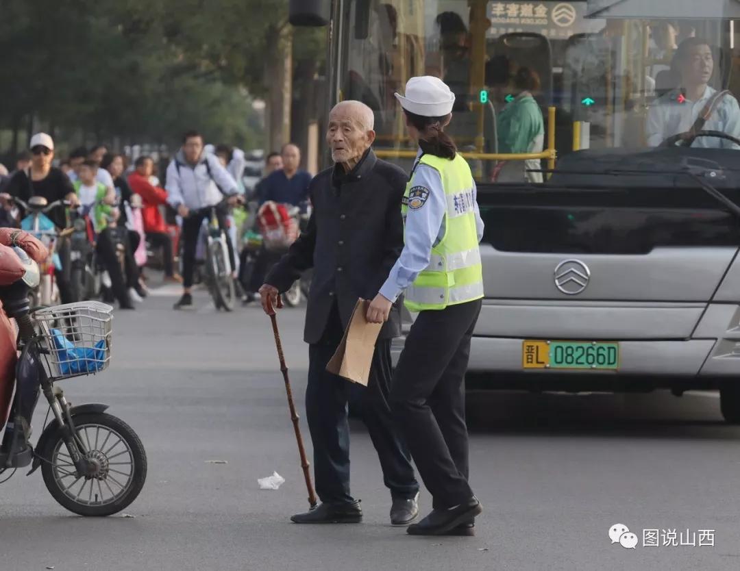 好人好事:女交警搀扶行动不便的老人过马路