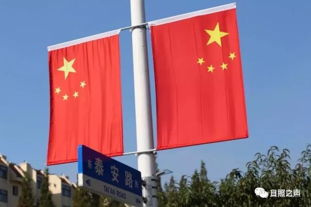 大街小道整齐悬挂起五星红旗 在蓝天白云绿树的映衬下 一抹抹"中国红"