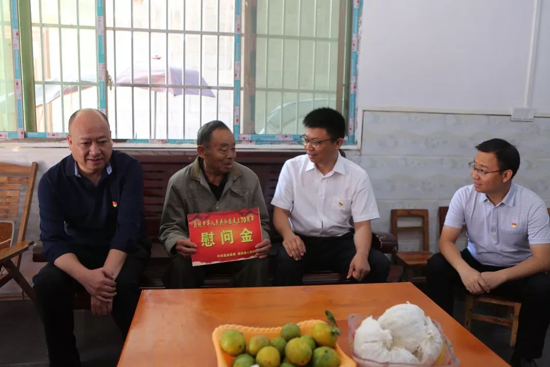 在覃汉周家叶霖一行分别来到在职残疾军人覃汉周和离任老村干覃庆坤的