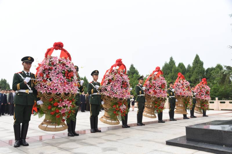 礼兵抬着五个花篮缓步走向烈士纪念碑