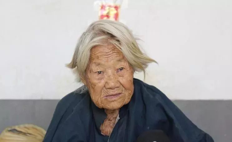 老人已经白发苍苍,院子中一股刺鼻的味道,铺在地上的草毡就是她的"床"