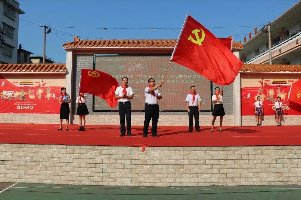 参加活动的领导向学校授予党旗,团旗和队旗.