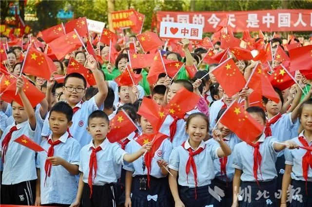 小学生们也挥动手中的国旗.