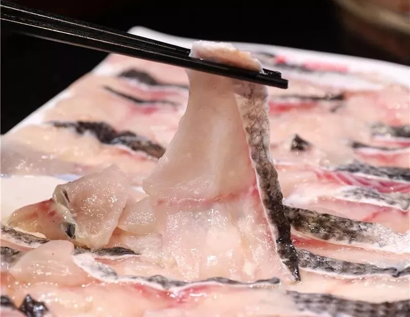 在娴熟且精细的刀工下将鱼肉切片,那白嫩的模样,吃货们见了都得咽