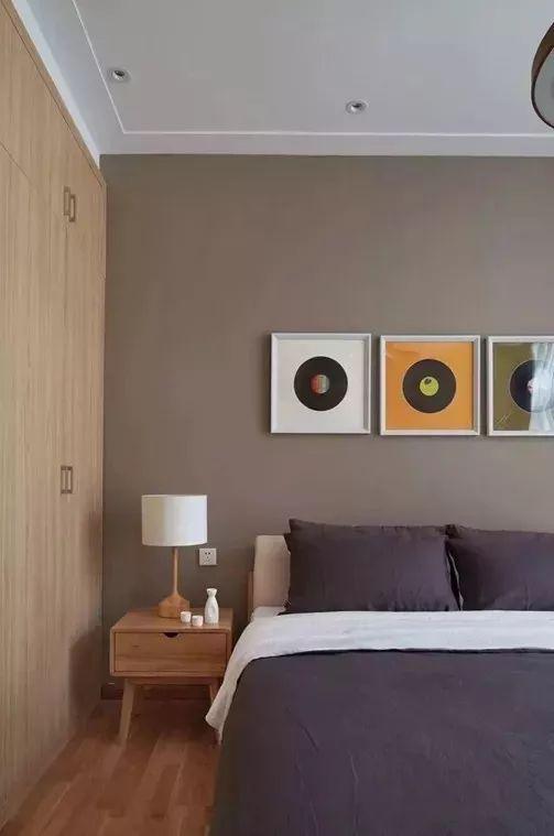 卧室在棕咖色的墙基础,搭配木质床,灰色床单与枕头,整体空间清新