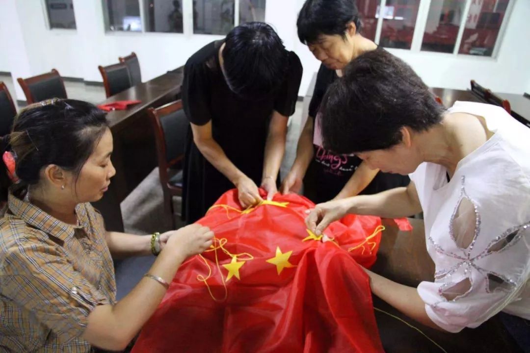 经过大家的共同努力,鲜艳的五星红旗终于绣好,大家争相和国旗合影