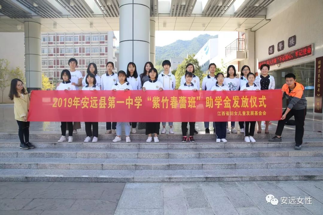 安远县妇联主席陈安琪,安远县第一中学副校长陈素珍为贫困学子发放